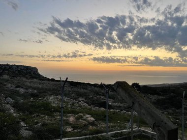 Golden Sunset Over Ayia NapaThe coastal cliffs of Ayia Napa are bathed in the golden light of sunset. Dramatic clouds scatter across the sky, creating a vibrant and serene scene overlooking the peaceful sea. clipart