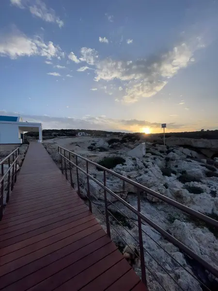 Kıbrıs Rum Kesimi 'nin Cape Greco kentindeki Agioi Anargyroi Şapeli' nde sakin bir günbatımı manzarası. Sahil yolu, sakin sahil uçurumlarına çıkar. Kiliselerin cazibesini, berrak gökyüzünü, deniz kıyısının engebeli güzelliğini vurgular..