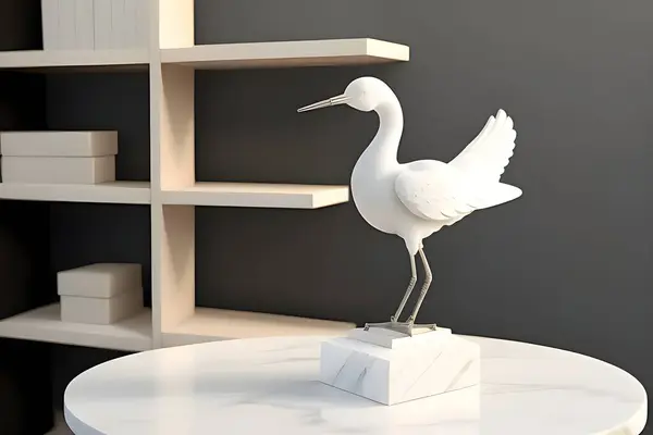 A sophisticated white crane sculpture displayed on a marble pedestal. Perfect for modern interiors, this decor piece exudes elegance and minimalistic charm, enhancing any contemporary space.