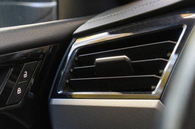 Close-up of a modern car air vent with sleek black detailing. clipart