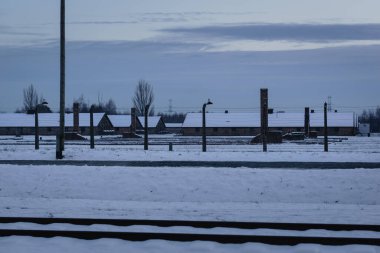 Barbed Wire and Chimneys: The Remnants of Auschwitz Grounds. clipart