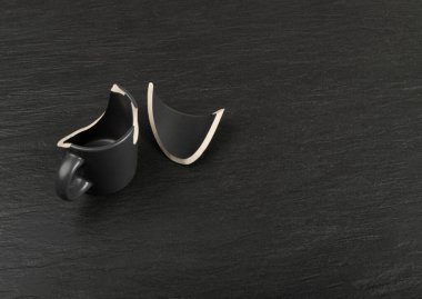 Broken Mug, Black Ceramic Cup Pieces, Smashed Teacup, Careless Concept, Empty Broken Mug on Black Background