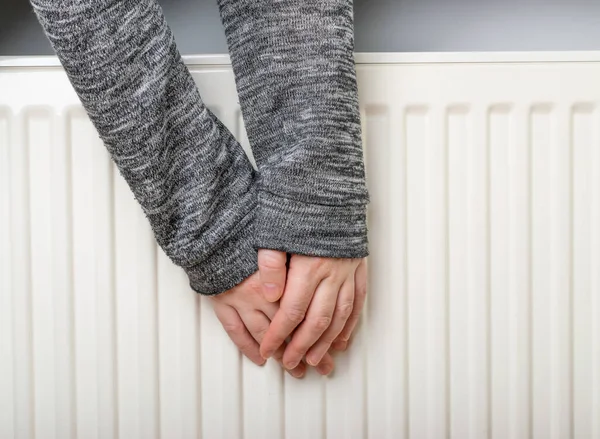 Warming Hands on White Radiator, Man Warms his Hand at Home, Cold Winter, Expensive Electricity Saving Concept, Copy Space
