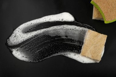Natural Soapy Sponge with Foam, Eco Brown Sponges, Eco Friendly Hygiene Accessory, Scotch Brite Dishwasher on Black Background, Copy Space