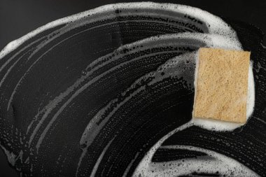 Natural Soapy Sponge with Foam, Eco Brown Sponges, Eco Friendly Hygiene Accessory, Scotch Brite Dishwasher on Black Background, Copy Space
