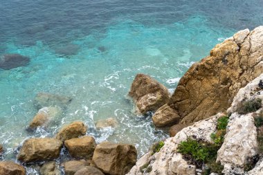Foamy Transparent Sea Waves, Blue Clear Water on Rocky Beach Texture Background, Azure Ocean Water, Rocky Shore Pattern, Stone Shoreline, Vacation Concept