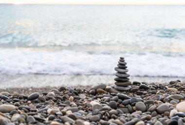 Stone pyramid. Pebbles balance pile, harmony zen stones, balance stack, sea pebble pyramid on shoreline, relaxation and peace concept