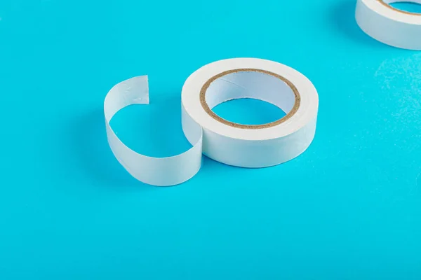 White Electrical Tape, Plastic Duct Tape Rolls, Colored Adhesive Tapes on Blue Background