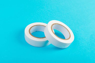 White Electrical Tape, Plastic Duct Tape Rolls, Colored Adhesive Tapes on Blue Background