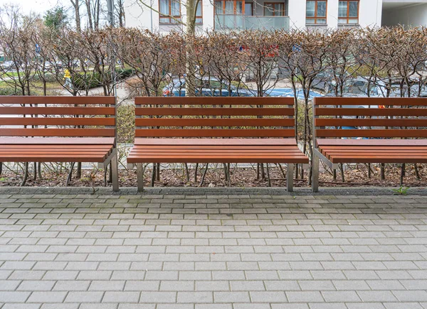 公園内の新しい近代的なベンチ 屋外都市建築 木のベンチ 屋外椅子 都市公共家具 空のプランクシート レクリエーションエリアの快適なベンチ — ストック写真