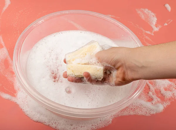 Basin Soapy Water Hand Holds Soapy Sponge Foam Pink Background — Foto de Stock