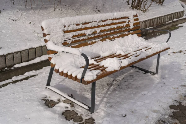 stock image Wooden Bench in Snow, Frozen Winter Park, Outdoor City Architecture, Snowy Wooden Benches, Empty Plank Seat in Snowfall, Seasonal Travel