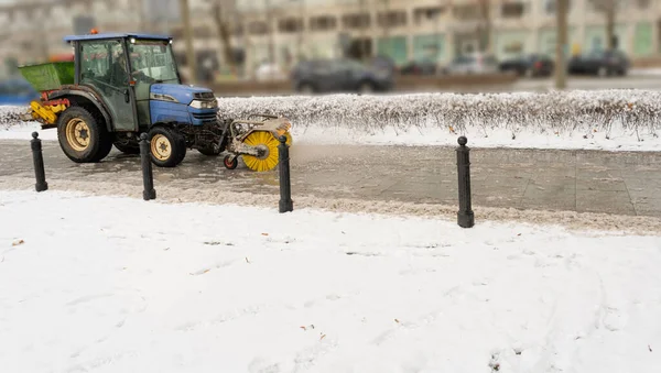 Salting Winter Road Maintenance, Road Salt Mini Tractor Spreader, Snow Plow Truck on Icy Street, Spreading Deicing Salt