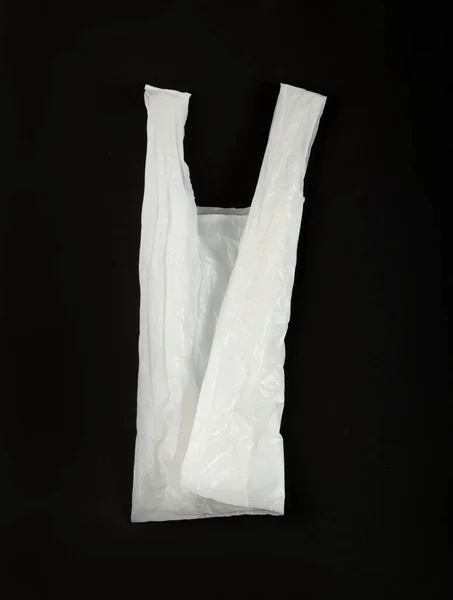 黒い背景の折られた白いプラスチック袋 ショッピングの後で粉砕されたプラスチック袋 セロファンの包装の廃棄物 使用された粉砕された使い捨て可能な袋 — ストック写真