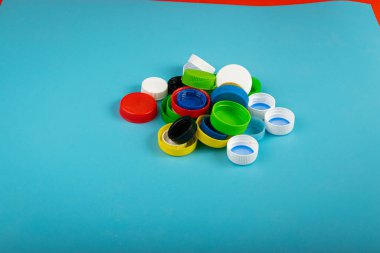 Plastik şişe kapağı yığını. Geri Dönüşüm HDPE Materyal Grubu, Çember Polietilen Lid Seti, Mavi Arkaplan Renkli Caps Grubu