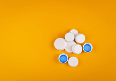 Plastik şişe kapağı yığını. HDPE Geri Dönüşüm Malzeme Grubu, Çember Polietilen Lid Seti, Sarı Arkaplan Renkli Caps Grubu