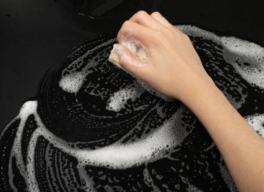Natural Soapy Sponge with Foam, Eco Brown Sponges, Eco Friendly Hygiene Accessory, Scotch Brite Dishwasher in Hand on Black Background, Copy Space
