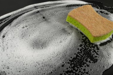 Natural Soapy Sponge with Foam, Eco Brown Sponges, Eco Friendly Hygiene Accessory, Scotch Brite Dishwasher on Black Background, Copy Space