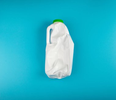 Boş Plastik Süt Şişesi, Buruşuk Beyaz Plastik Şişe, Küresel Kirlilik Konsepti, Mavi Arkaplanda Ezilmiş Hayvan Şişeleri