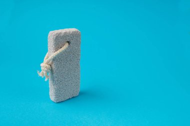 Blue Bacground 'daki sünger taşı, Grey Porous Lava Piece, Foot Care için Volkan Taşı, Basalt Extrusive Igneous Rock, Renk Arkaplanındaki Ayak Sağlığı Süngeri Taşı, Spa Konsepti