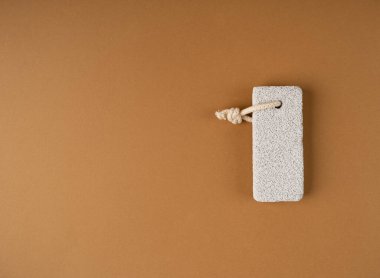 Brown Bacground 'daki sünger taşı, Grey Porous Lava Piece, Foot Care için Volkan Taşı, Basalt Extrusive Igneous Rock, Foot Wellness Püf taşı Renk Arkaplanı, Spa Concept