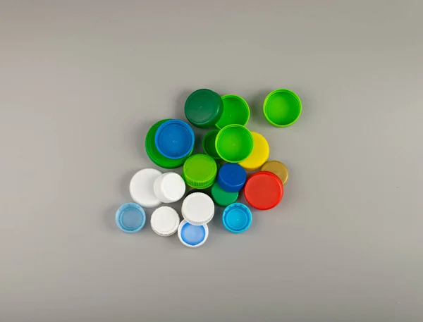 Plastic Bottle Caps Pile. Recycling HDPE Material Group, Circle Polyethylene Lid Set, Colorful Caps Group on Grey Background