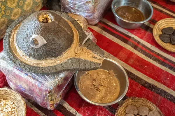 stock image Traditional argan oil production setup, stone grinder, argan seeds, woven baskets, metal bowls, brown paste, rustic, authentic, artisanal, Moroccan culture local craft