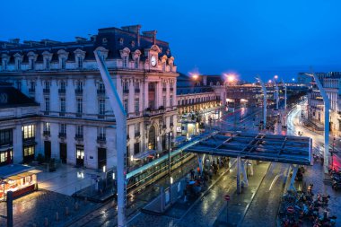 Bordeaux, Fransa, 17 Nisan 2024: Merkez Gare Saint-Jean yakınlarındaki TBM otobüs durağı Yağmurlu bir gecede tarihi bina, editoryal görüntü