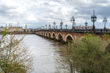 Bordeaux, France, April 17, 2024: Pont de Pierre or Stone Bridge in Bordeaux connects banks of Garonne river, urban tourism, old europe city editorial image clipart