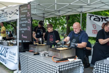 Varşova, Polonya, 8 Haziran 2024: Japon gıda tezgahı, takoyaki, ebiyaki, chizuyaki pazarları. Aşçılar geleneksel Japon sokak yemekleri, açık hava yemekleri, editoryal imaj