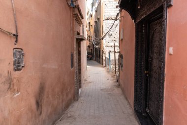 Marakeş, Fas, 10 Ocak 2024 Dar Marakeş sokakları, eski şehrin yıpranmış duvarları, otantik, tarihi Fas. Sıcak toprak tonlarında yaşlanmış binalar, kırsal cazibe, editoryal görüntü