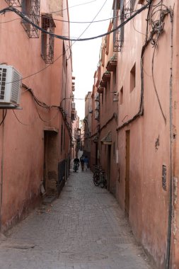 Marakeş, Fas, 10 Ocak 2024 Dar Marakeş sokakları, eski şehrin yıpranmış duvarları, otantik, tarihi Fas. Sıcak toprak tonlarında yaşlanmış binalar, kırsal cazibe, editoryal görüntü