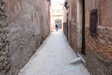 Marakeş, Fas, 10 Ocak 2024 Dar Marakeş sokakları, eski şehrin yıpranmış duvarları, otantik, tarihi Fas. Sıcak toprak tonlarında yaşlanmış binalar, kırsal cazibe, editoryal görüntü