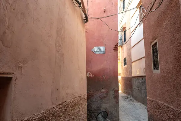 stock image Marrakech, Morocco, January 10, 2024: Narrow Marrakech streets, old town weathered walls, authentic, historical Morocco. Aged buildings in warm earthy tones, rustic charm, editorial image