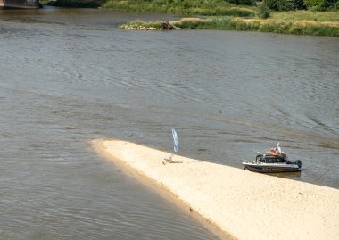 Varşova, Polonya, 16 Haziran 2024 Vistula River Sandy plajı PGE Narodowy Stadyumu yakınlarında. İnsanlar güneşleniyor ve dinleniyor, tekneler kıyıya yanaşıyor, beyaz kumlar, şehirde sıcak bir yaz günü, editör imajı.