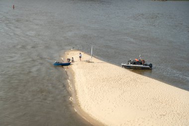 Varşova, Polonya, 16 Haziran 2024 Vistula River Sandy plajı PGE Narodowy Stadyumu yakınlarında. İnsanlar güneşleniyor ve dinleniyor, tekneler kıyıya yanaşıyor, beyaz kumlar, şehirde sıcak bir yaz günü, editör imajı.