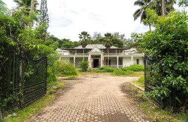 Praslin, Seyşeller, 3 Şubat 2025 Praslin, Seyşeller 'deki terk edilmiş Casino des Iles yolu çürümüş bir sömürge cephesi, kırık sütunlar ve aşırı gelişmiş bitki örtüsü editör imajı ile.