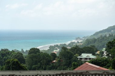Beau Vallon, Seyşeller, 2 Şubat 2025: Yeşil tepeler, evler ve ufuk çizgisine uzanan bir turkuaz okyanusla Seyşeller 'in manzaralı kıyı manzarası