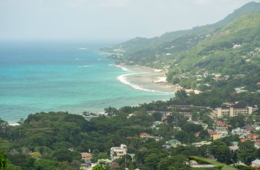 Beau Vallon, Seyşeller, 2 Şubat 2025: Tepeden Beau Vallon Sahili panoramik manzarası, yemyeşil evler ve arka plandaki turkuaz okyanus.