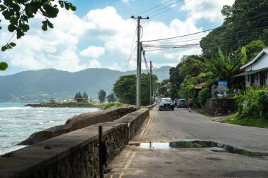 Beau Vallon, Seyşeller, 31 Ocak 2025: Sahil yolu, okyanus, dağlar ve yeşillik resmi olan Danzil Otobüs İstasyonu 'nun son otobüs durağından görüntüler
