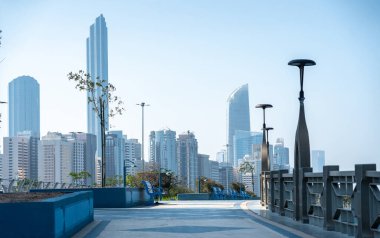 Abu Dabi, BAE, 29 Ocak 2025: Abu Dabi 'de deniz kenarında mavi kaldırımlı, dekoratif parmaklıklı ve gökyüzü manzaralı bir gezinti alanı.
