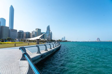 Abu Dabi, BAE, 29 Ocak 2025: Abu Dabi 'deki Corniche gezinti alanı, modern gökdelenler, kıvrımlı bir yürüyüş yolu ve manzaralı bir deniz manzarası.