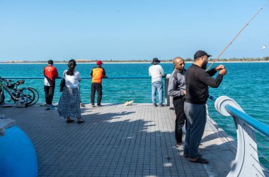 Abu Dabi, BAE, 29 Ocak 2025: Abu Dabi 'deki Corniche Sahili' nde balık tutan insanlar, liman ve açık hava aktivitelerinin tadını çıkarıyorlar.