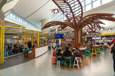 Abu Dabi, BAE, 30 Ocak 2025: Abu Dabi Havalimanı 'ndaki yemek salonu yolcuları yemek, modern tasarım ve çeşitli restoranlar editoryal görüntü ile