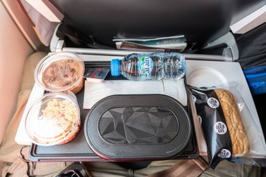 Abu Dabi, BAE, 30 Ocak 2025: Etihad Havayolları uçuş yemeği, su, salata, tatlı, ekmek ve kaplanmış ana yemek görüntüsü