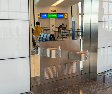 Abu Dabi, BAE, 30 Ocak 2025: Gidiş kapısının yanındaki Abu Dabi Havalimanı 'nda bir içme suyu istasyonu, transit yayın görüntüsü olan yolculara su sağlıyor