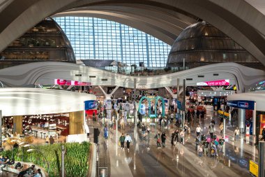 Abu Dabi, BAE, 30 Ocak 2025: Abu Dabi Havalimanı yolcuları, gümrüksüz dükkanlar, bir yemek salonu ve modern mimari görüntü.