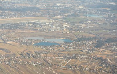Kar manzaralı uçak penceresi Polonya arazileri ve köyleri, Krakow banliyöleri, uçağın uçtuğu yerler, aşağıdaki kışın kırsal manzarası.