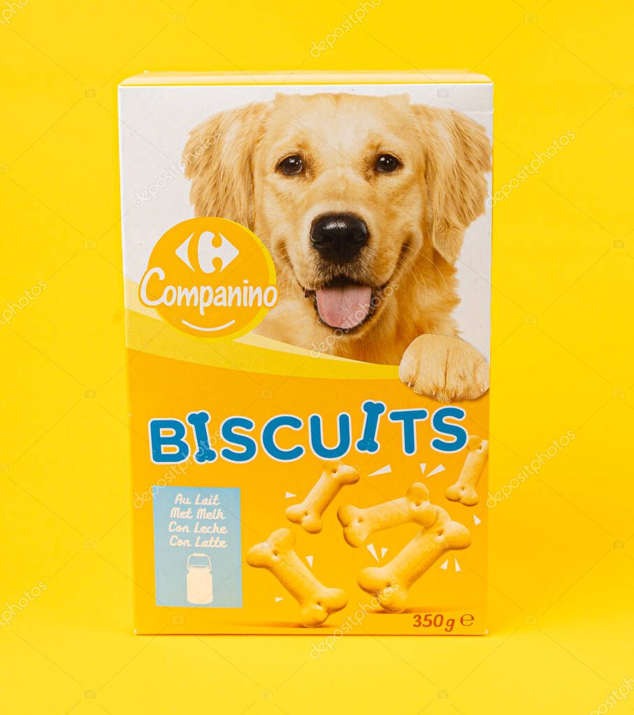 Warsaw, Poland, March 3, 2025: Dog food pack with biscuits, canine cookie, bone shape biscuits by Carrefour on yellow background, editorial image