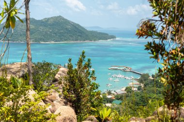 Seyşeller 'deki Hint Okyanusu' nun tekneleri, tropikal ormanları ve turkuaz sularıyla Baie Sainte Anne 'e bakan Praslin Adası' ndaki tepenin manzarası.